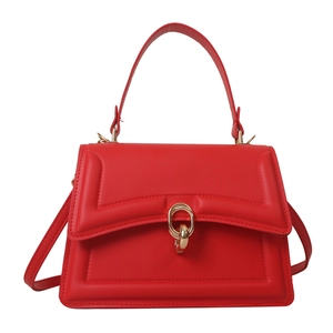 Fashionable red structured tote bag with geometric embossed design and gold ring hardware