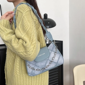 Light blue faux denim underarm bag with quilted diamond pattern and floral chain
