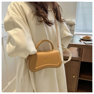 Detail of caramel crescent crossbody bag with wave design and gold fashion logo