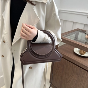 Minimalist deep brown geometric leather handbag with top handle and shoulder strap