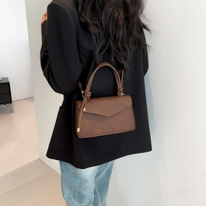 Brown envelope-style crossbody bag with top handle and gold hardware for women