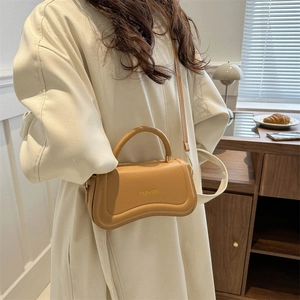 Vintage light brown leather crossbody bag with rounded base and fashion engraving
