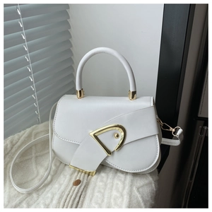 Detail showing white leather saddle bag with gold metal buckle and detachable strap