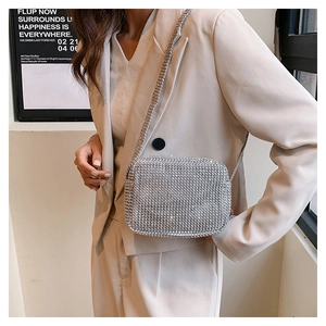 Détail d'un sac bandoulière carré en strass argentés brillants avec chaîne fine