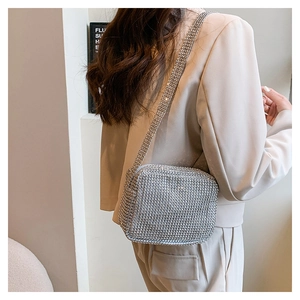 Detail view showing a silver rhinestone square shoulder bag worn by a model