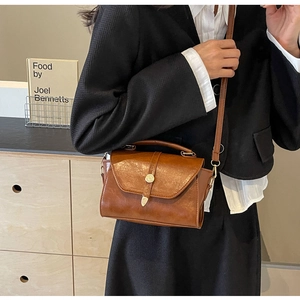 Détail du sac à main vintage en cuir marron avec fermoir doré et bandoulière réglable