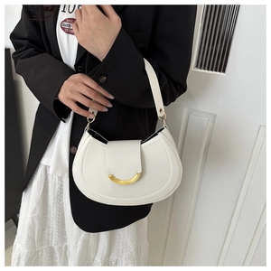 Dettaglio della borsa hobo bianca con chiusura in metallo dorato a forma di U sulla patta