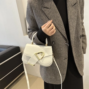 Elegant white leather saddle bag with gold D-buckle, modeled on a grey herringbone blazer