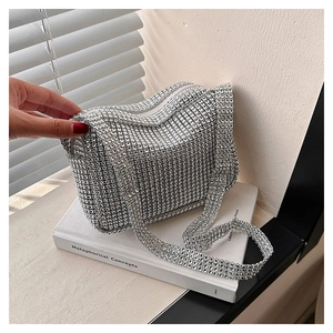 Detailed close-up of sparkling silver rhinestone handbag on a minimalist book background