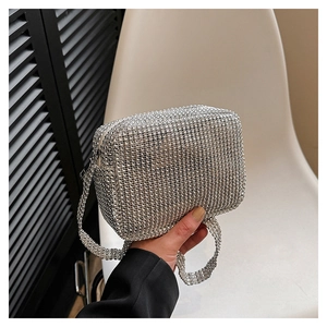 Close-up of a silver rhinestone evening clutch bag with sparkling strap for parties