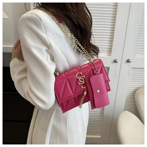 Détail du sac à chaîne matelassé rose avec boucle en S et mini pochette assortie