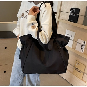 Detail of black nylon tote bag with drawstring closure for daily commute or travel use