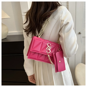Détail du sac matelassé rose à chaîne avec fermoir doré en S et mini porte-monnaie