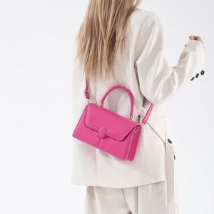 Borsa a tracolla minimalista in pelle rosa fucsia con fibbia dorata indossata da modella