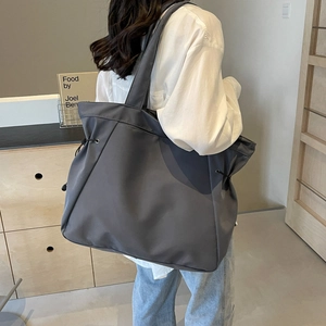 Minimalist large charcoal tote bag with drawstring detail shown on model back
