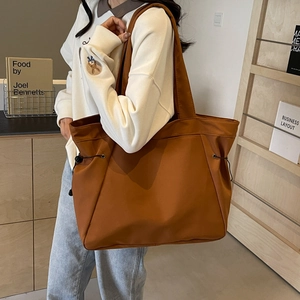 Large caramel tote bag with adjustable drawstring for daily commute and travel