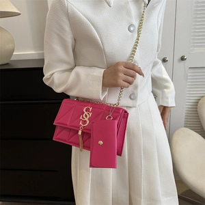 Sac bandoulière rose matelassé avec chaîne dorée et pendentif à pompon chic
