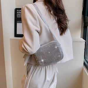 Sparkly silver rhinestone crossbody evening bag worn with a chic beige blazer
