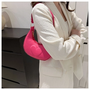 Detail of pink crescent bag with embossed heart pattern on smooth matte leather finish