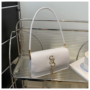 Detail of white crocodile texture baguette bag with gold metal logo and tassel