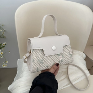 Elegant white leather crossbody bag with delicate floral lace embroidery and top handle