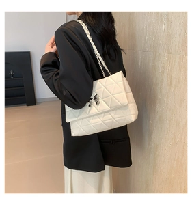 Détail du sac bandoulière matelassé blanc crème avec fermoir métallique en nœud