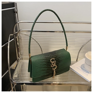 Detail of dark green embossed shoulder bag with gold metal buckle and tassel charm