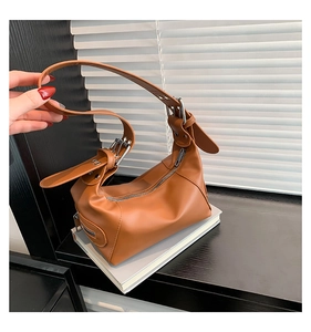 Detail der karamellfarbenen PU-Leder Baguette-Tasche mit Silberschnalle und Trageriemen