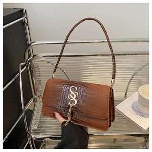 Detail of brown croc-embossed shoulder bag with golden SS logo and metallic tassels