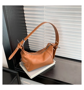 Detailaufnahme der braunen Leder-Hobo-Tasche mit breitem Gurt und Metallreißverschluss