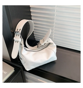 Detail der weißen Mond-Umhängetasche mit silbernen Ösen und Schnalle am Lederriemen