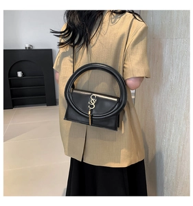 Detailansicht schwarze Lederhandtasche mit rundem Griff und goldener S-Schnalle
