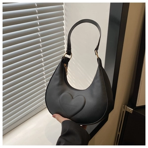 Detail of the black crescent bag showing the 3D heart embossing and gold hardware