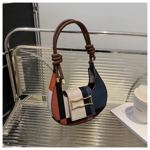 Detail der Baguette-Tasche im Color-Block-Design mit Ledergriff und Goldschnalle