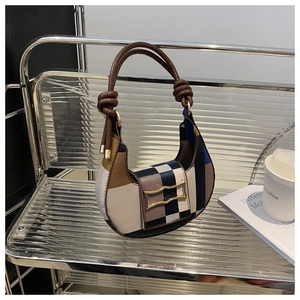 Detailansicht der Retro-Karo-Handtasche mit Lederknotengriff und goldenem Bogenverschluss