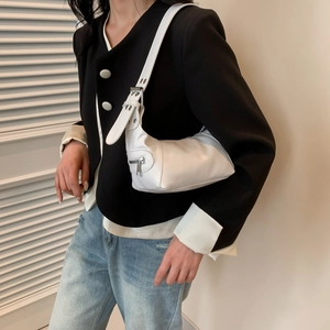 Schicke weiße Hobo-Schultertasche mit silberner Schnalle zu einem schwarzen Blazer