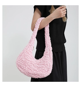 Dettaglio borsa a mezzaluna rosa con trama a bolle 3D e design a pieghe