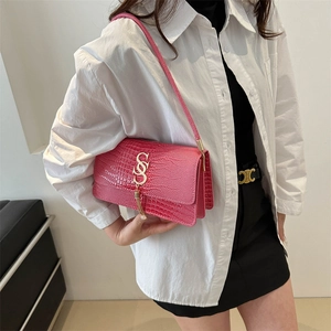Fashionable rose pink croc-embossed underarm bag with gold logo and tassel accent