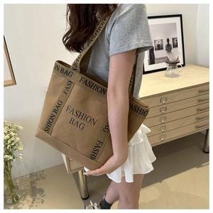 Close-up of khaki canvas tote bag with fashion lettering and dual strap handles
