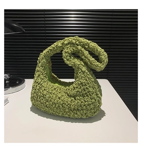 Dettaglio borsa a mano verde arricciata in tessuto a bolle con texture increspata