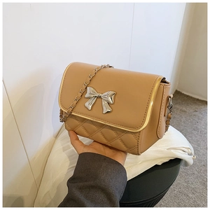 Detail view of khaki crossbody bag featuring quilted PU leather and a silver metal bow