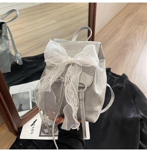 Silver mini backpack with large white lace bow and drawstring closure detail