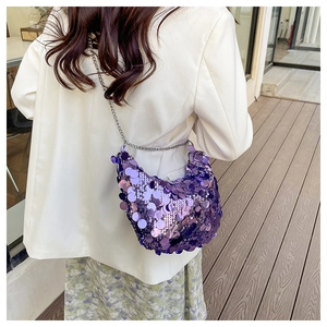 Detail of purple sequin hobo bag with silver chain strap shown in a lifestyle setting