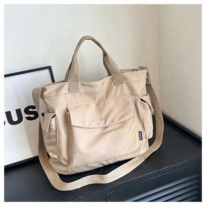 Detail of multi-functional canvas tote with adjustable strap and front snap pocket