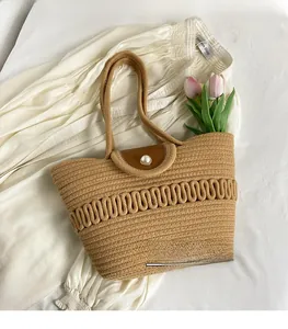 Detail of woven straw tote bag with brown leather flap and large pearl closure