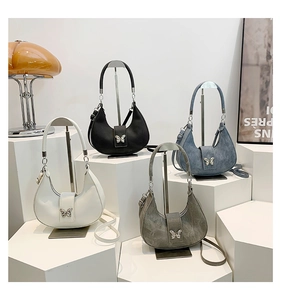Dettaglio di quattro borse hobo con fibbie a farfalla argentate in bianco nero blu e grigio
