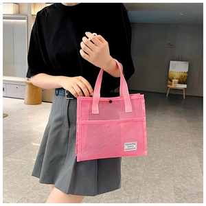 Detail of rose pink mesh tote bag featuring reinforced handles and fashion label