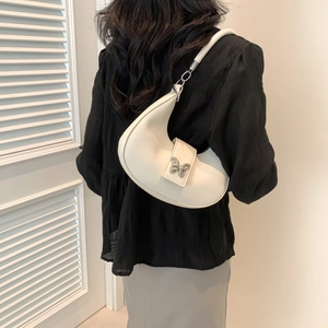 Borsa sottobraccio a mezzaluna bianca alla moda con fibbia a farfalla argento su modella