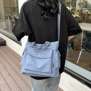 Minimalist fog blue large capacity tote bag shown on model in a modern outdoor setting