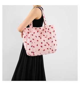 Texture dettagliata della borsa tote in velluto rosa con stampa di fragole rosse
